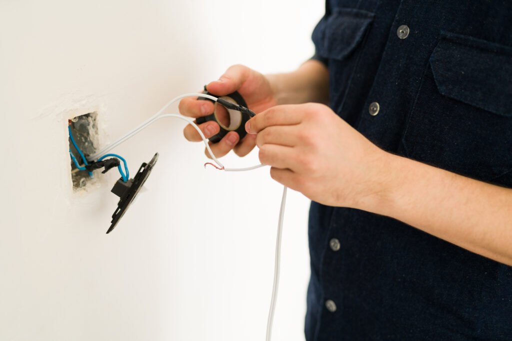 handyman putting tape on broken cables Testing Low Voltage image