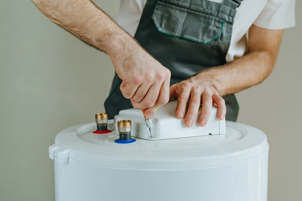 technician fixing water geyser